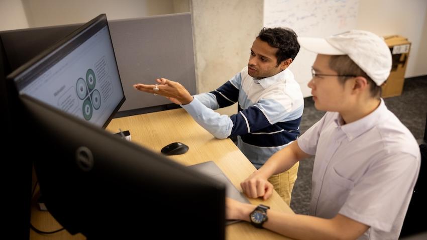 Two students looking at computer monitor