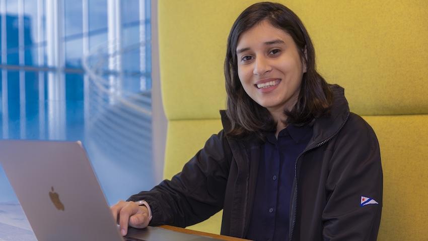 Umme Ammara sits in a booth with her laptop in front of her